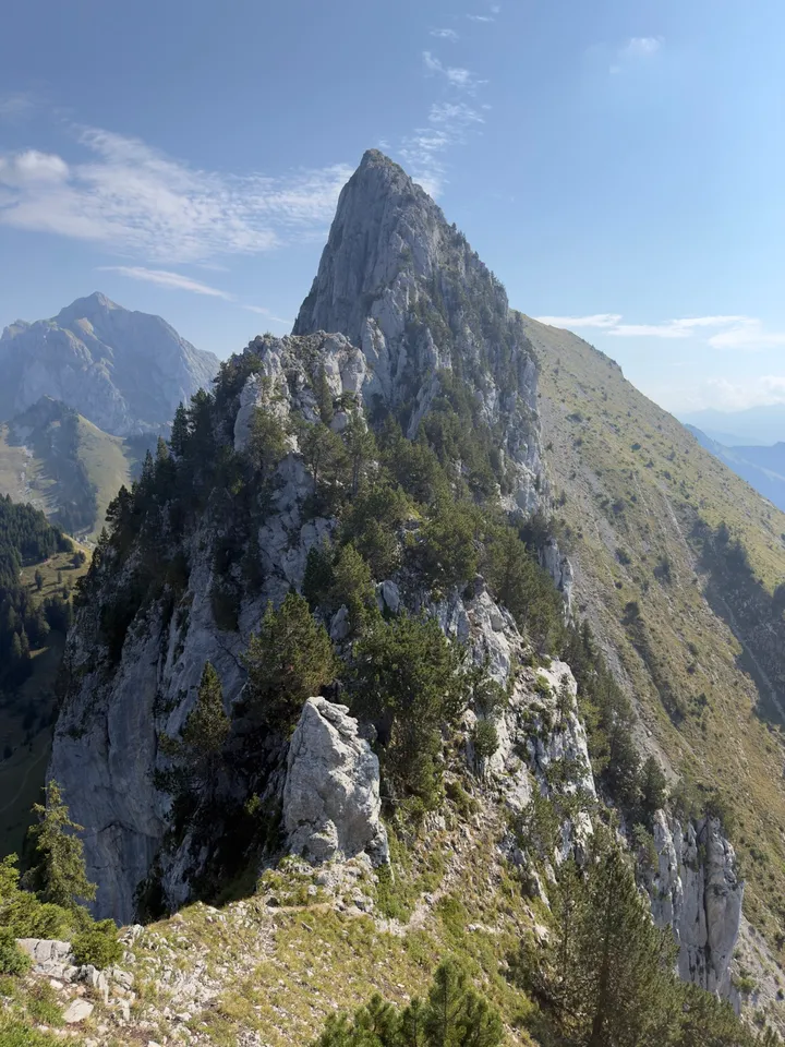 A jagged limestone ridge leading towards a tall rock tower, with steep drops on both sides.